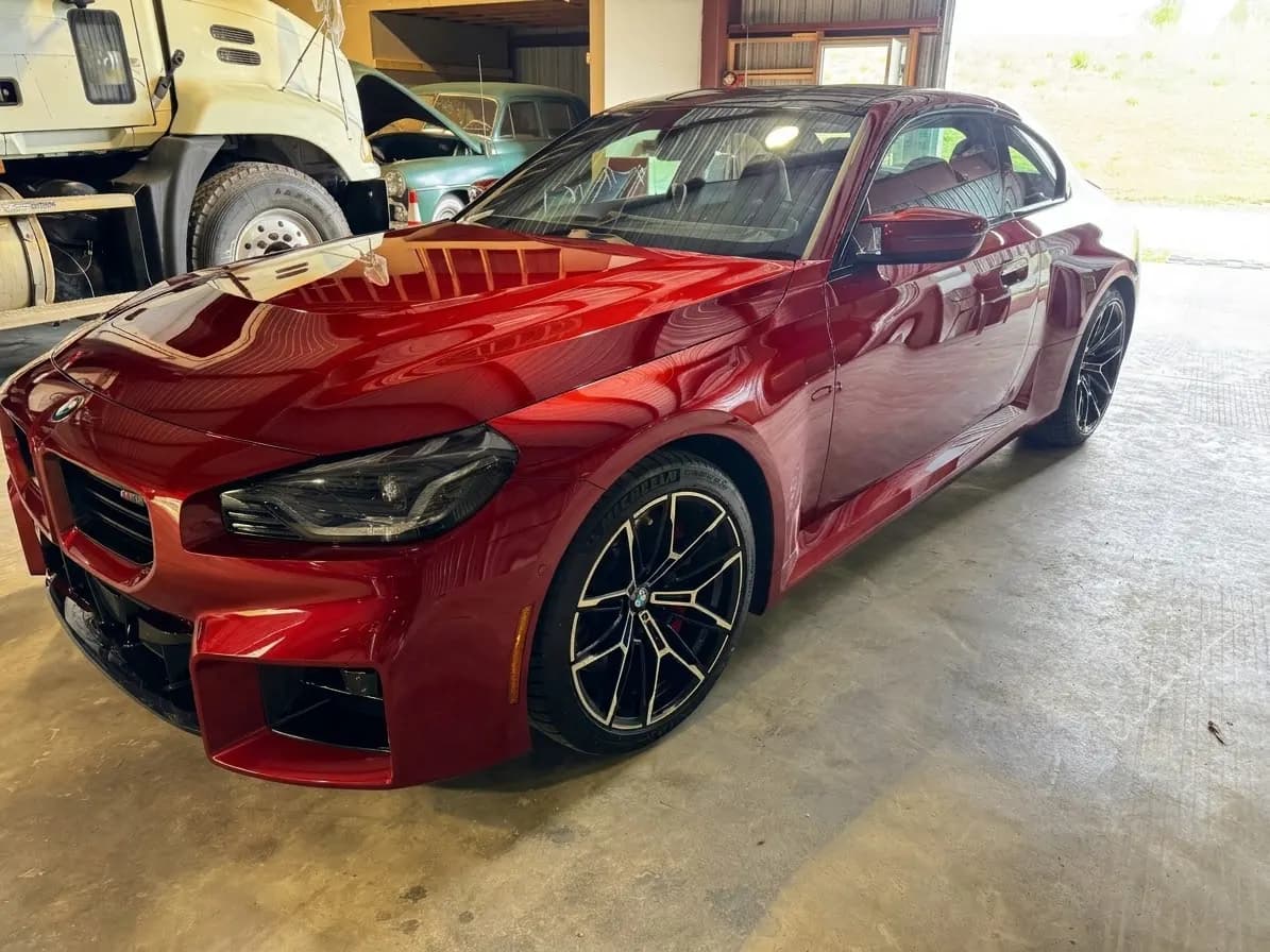 Sedán BMW rojo de alto rendimiento dentro del taller