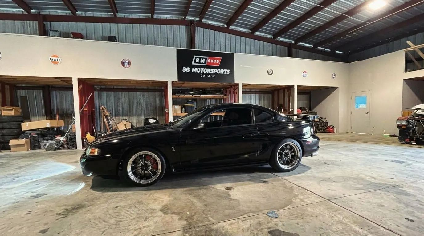 Mustang clásico negro estacionado dentro del taller